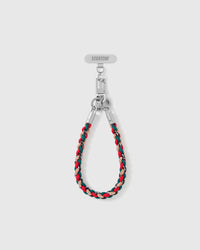 Heather strap looped short as a wrist strap, showing the red and pine braided cord and silver-tone hardware