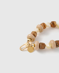 Close-up of the 18K gold-plated hook, engraved STICKYZOO disc and toffee marbled beads — no two swirls alike