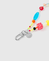 Close-up of silver-tone engraved clasp with polka-dot dice and translucent blue beads