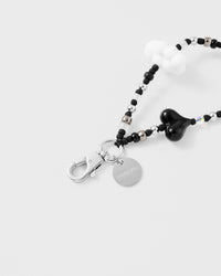 Close-up of silver-tone clasp and engraved STICKYZOO charm disc with black and silver beads