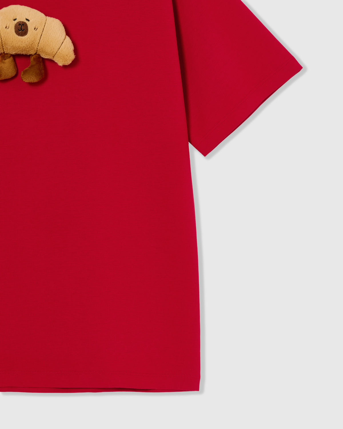 Detail of hem and fabric on STICKYZOO red Runaway Croissant T-Shirt showing premium cotton weight