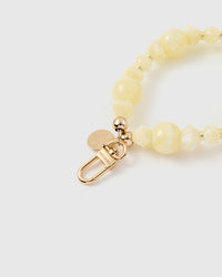 Close-up of gold-plated STICKYZOO clasp and charm disc with lemon yellow beads