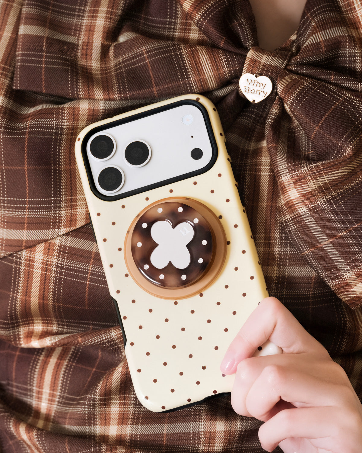 Hand holding the lucky clover phone case with the tortoiseshell MagSafe grip extended from the back