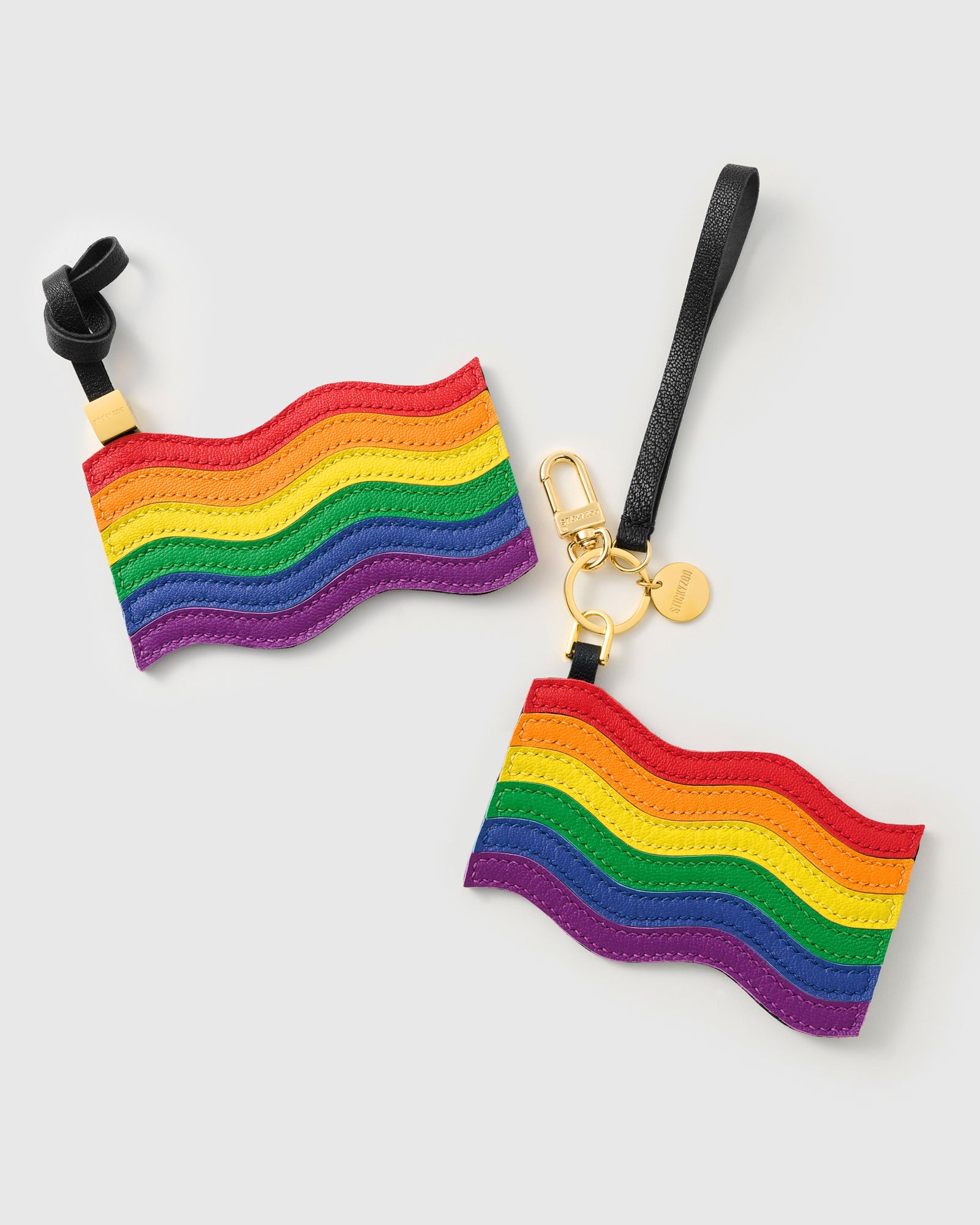 Both pride flag charm attachment styles — leather strap loop and 18K gold-plated keychain clip with STICKYZOO coin
