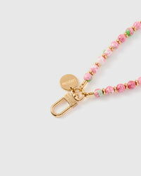 Close-up of gold-plated clasp and engraved STICKYZOO charm disc with pink and green marble beads