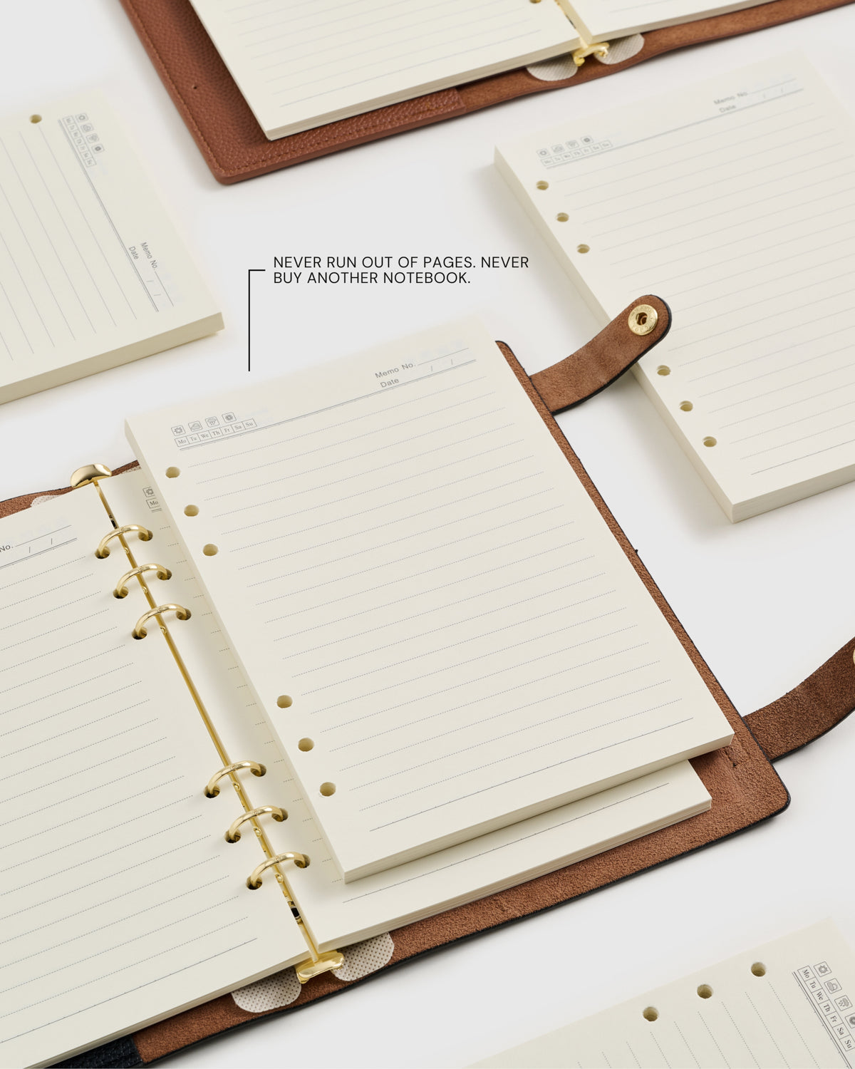 Several A5 refill packs and ring notebooks laid out together — premium lined paper made for long-term daily use.