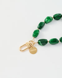 Close-up of gold-plated clasp and engraved STICKYZOO disc with emerald marble beads