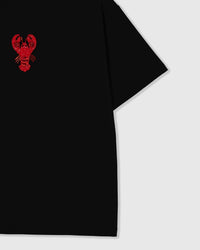 Styled layflat of the black STICKYZOO Lobster T-Shirt showing the beaded lobster applique and the relaxed dropped-shoulder drape.