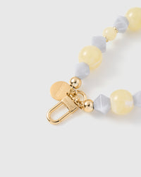 Close-up of engraved STICKYZOO gold clasp with butter and frosted grey beads