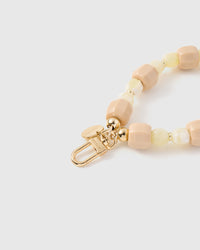 Close-up of gold-plated clasp and engraved STICKYZOO charm disc with apricot and butter beads