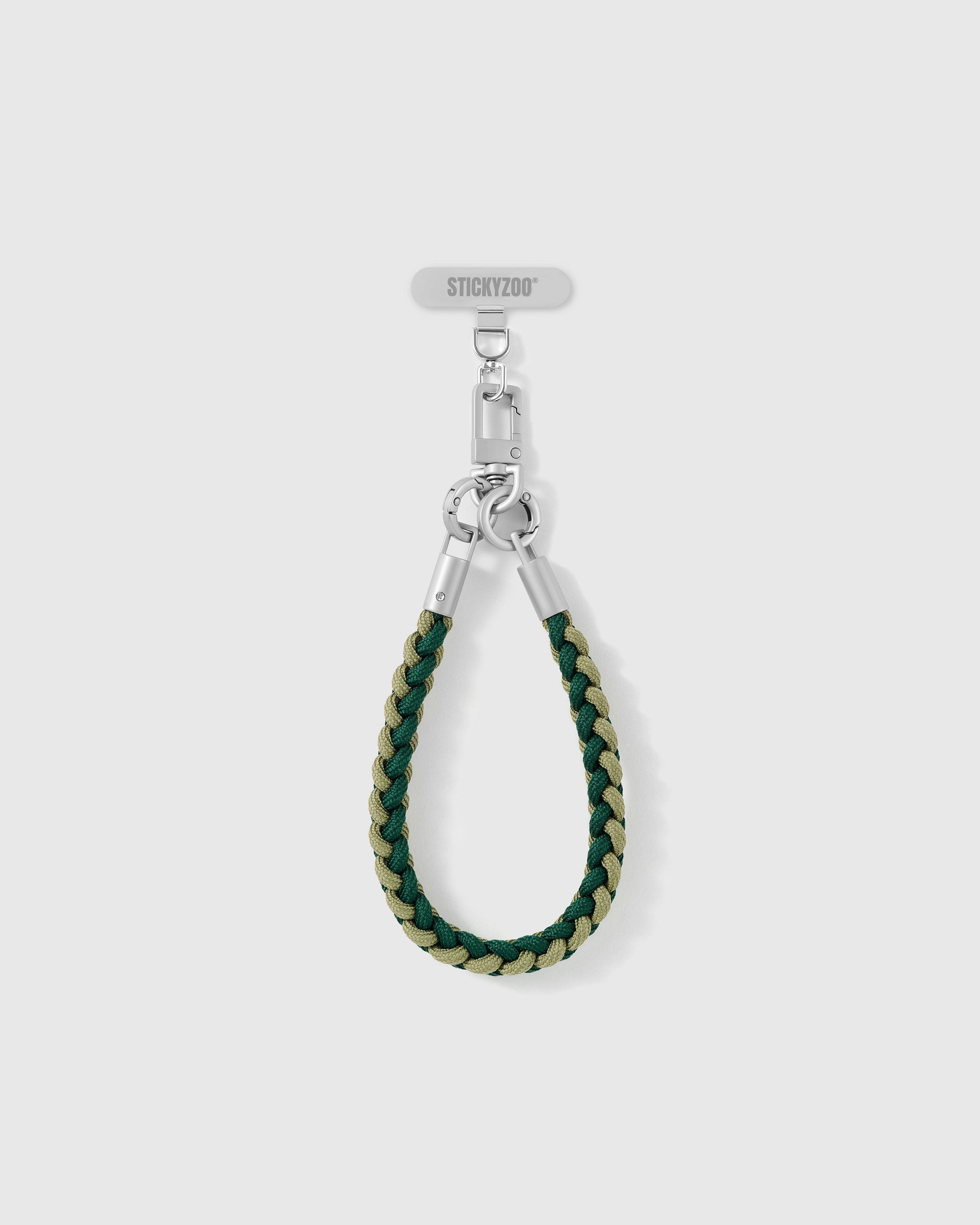 Pine strap looped short as a wrist strap, showing the forest and sage braided cord and silver-tone hardware