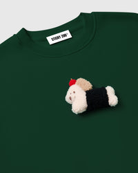 Back view of green cotton sweatshirt showing ribbed cuffs and relaxed oversized fit