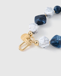 Close-up of gold-plated engraved clasp with sapphire and white marble beads