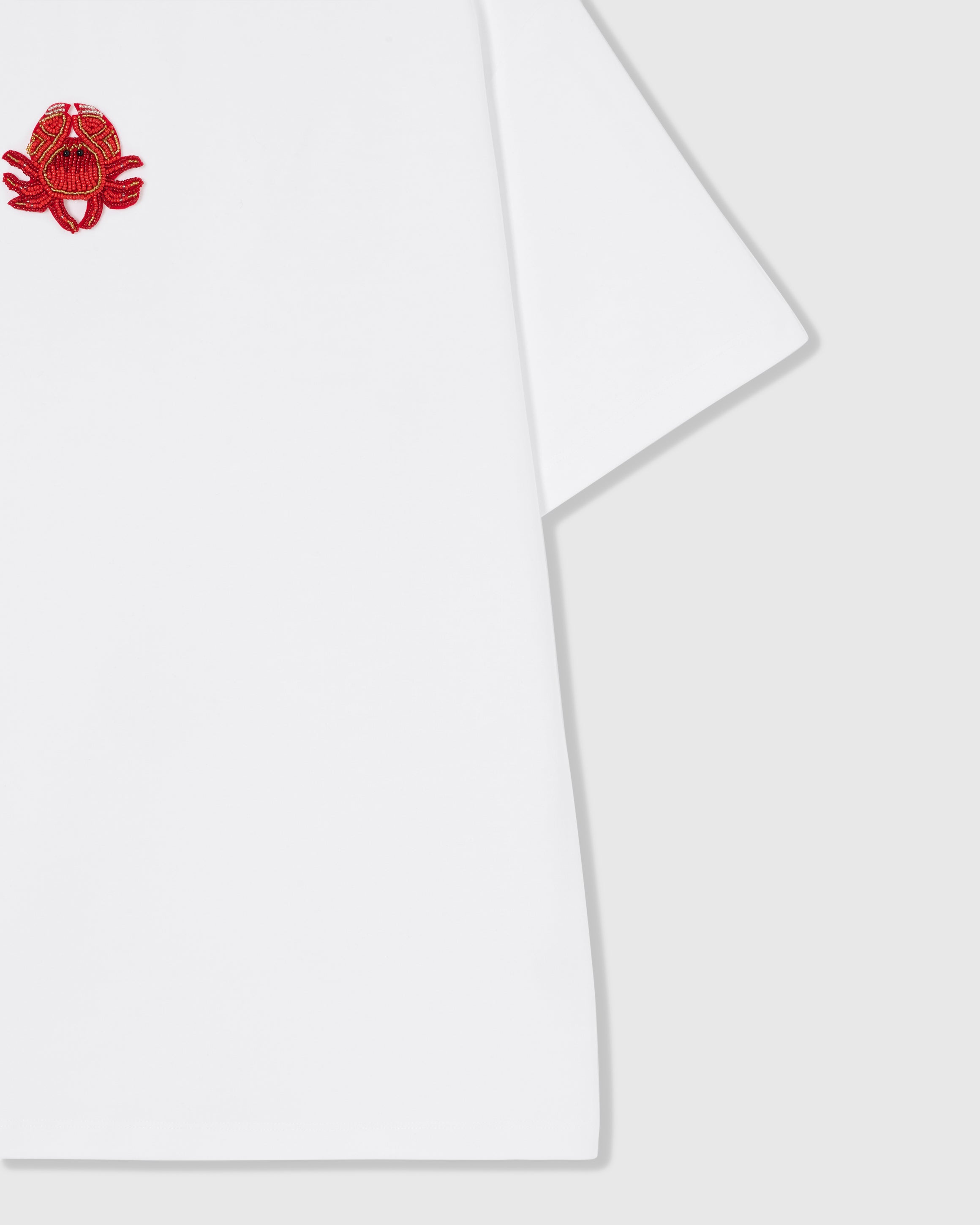 Styled layflat of the white STICKYZOO Crab T-Shirt showing the beaded crab applique and the relaxed dropped-shoulder drape.