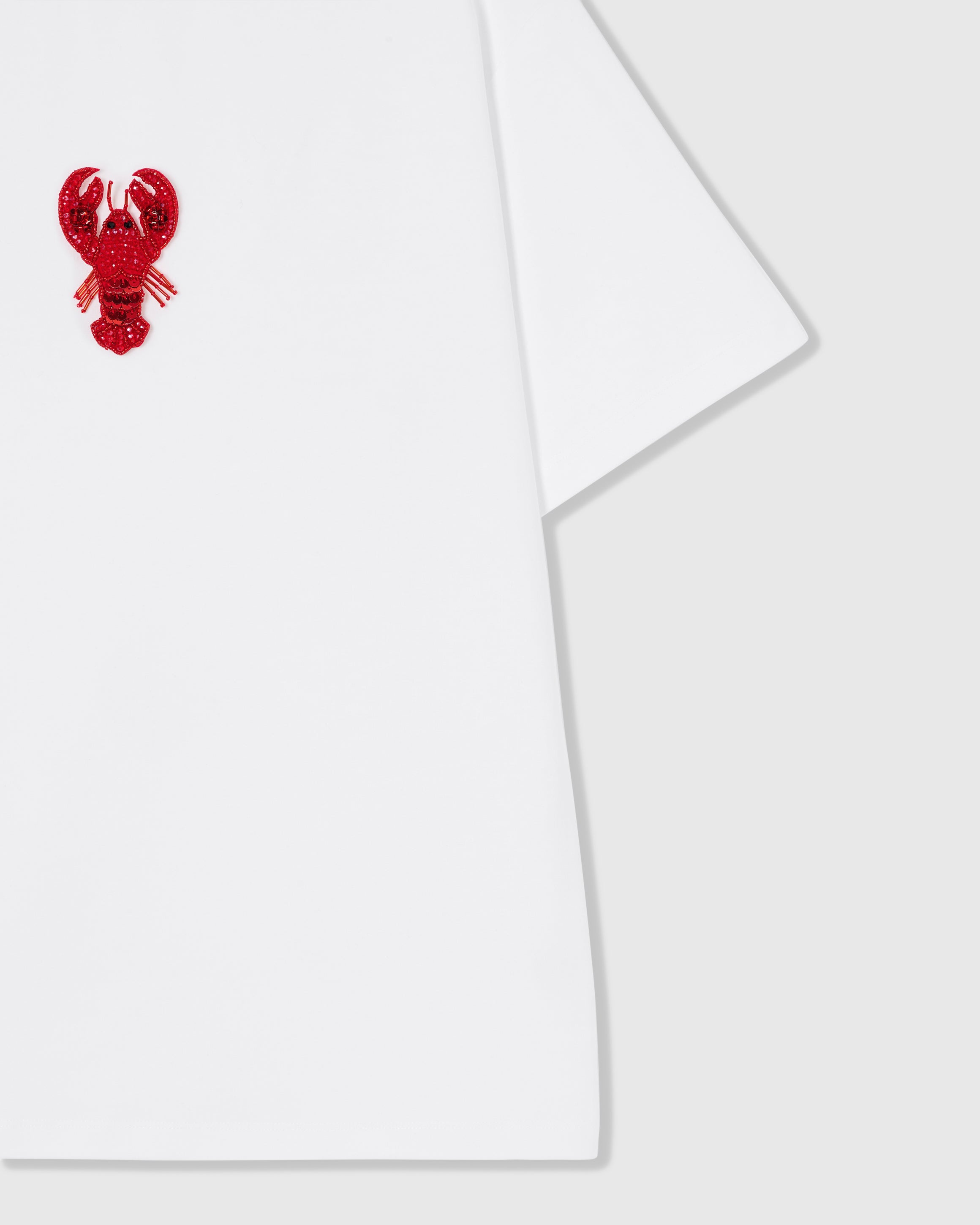 Styled layflat of the white STICKYZOO Lobster T-Shirt showing the beaded lobster applique and the relaxed dropped-shoulder drape.