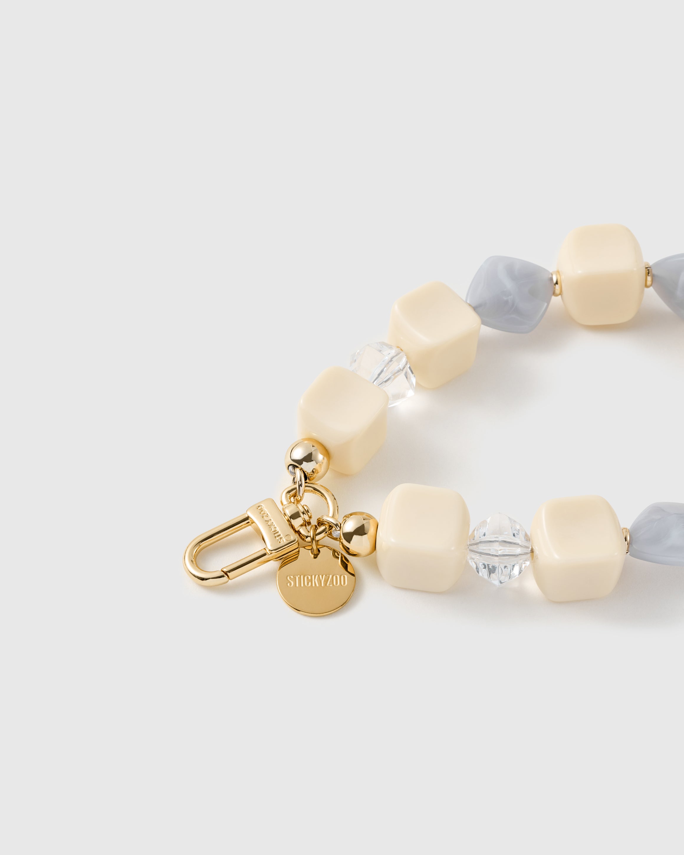 Close-up of the 18K gold-plated hook, engraved STICKYZOO disc and frost marbled beads — no two alike