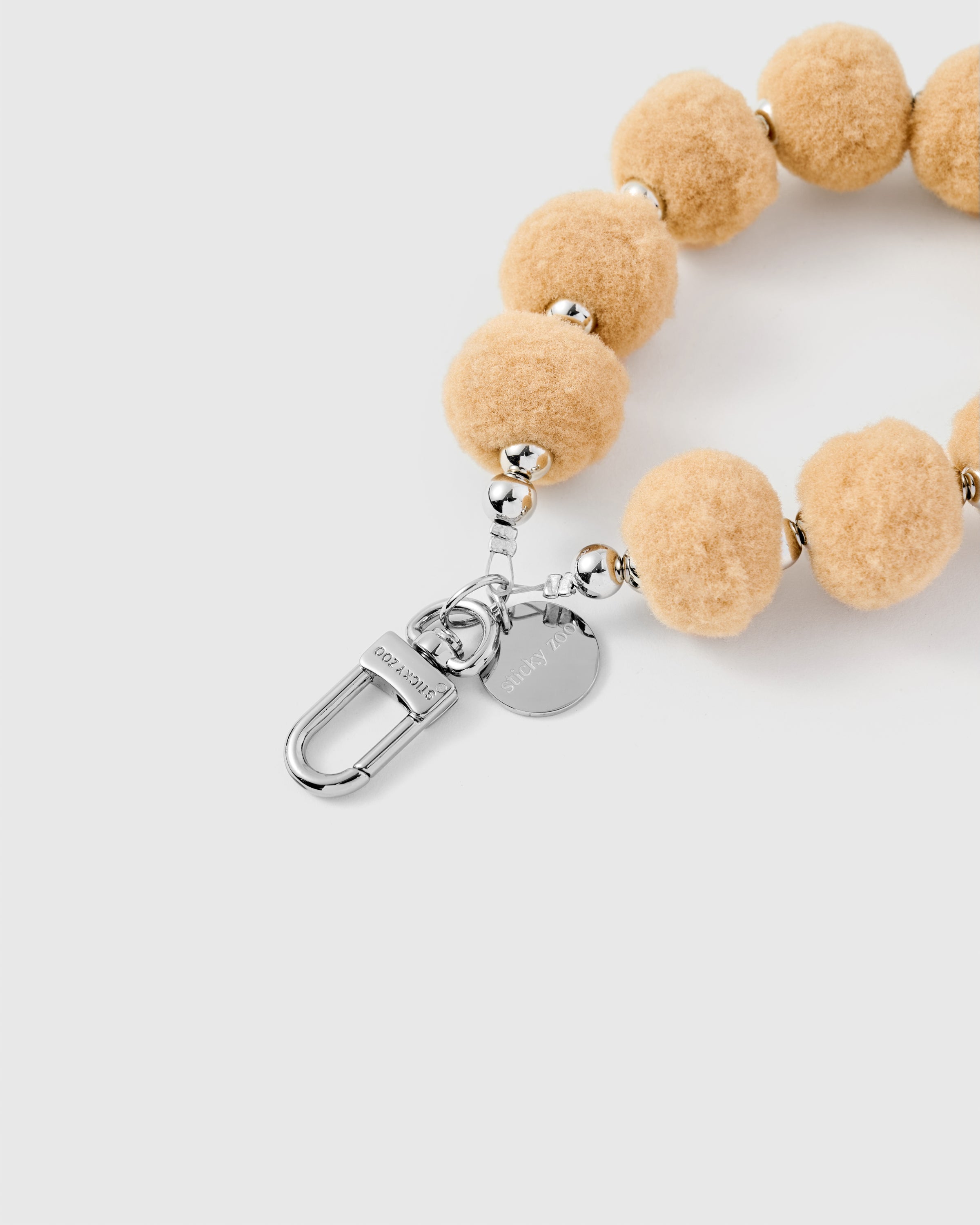 ベージュの毛玉付き携帯紐