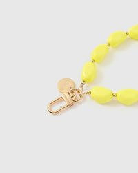 Close-up of gold-plated hardware and engraved STICKYZOO connector with neon yellow beads
