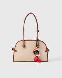Close-up of handmade Santa Dachshund Stocking leather bag charm — embroidered white snowflakes on red French Alran goatskin stocking, dachshund in Santa hat. STICKYZOO.