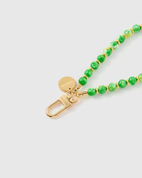 Close-up of jade green speckled stone beads showing natural golden fleck patterns with gold spacers