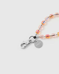 Inside of phone case showing STICKYZOO Phone Strap Card with peach crystal strap attached