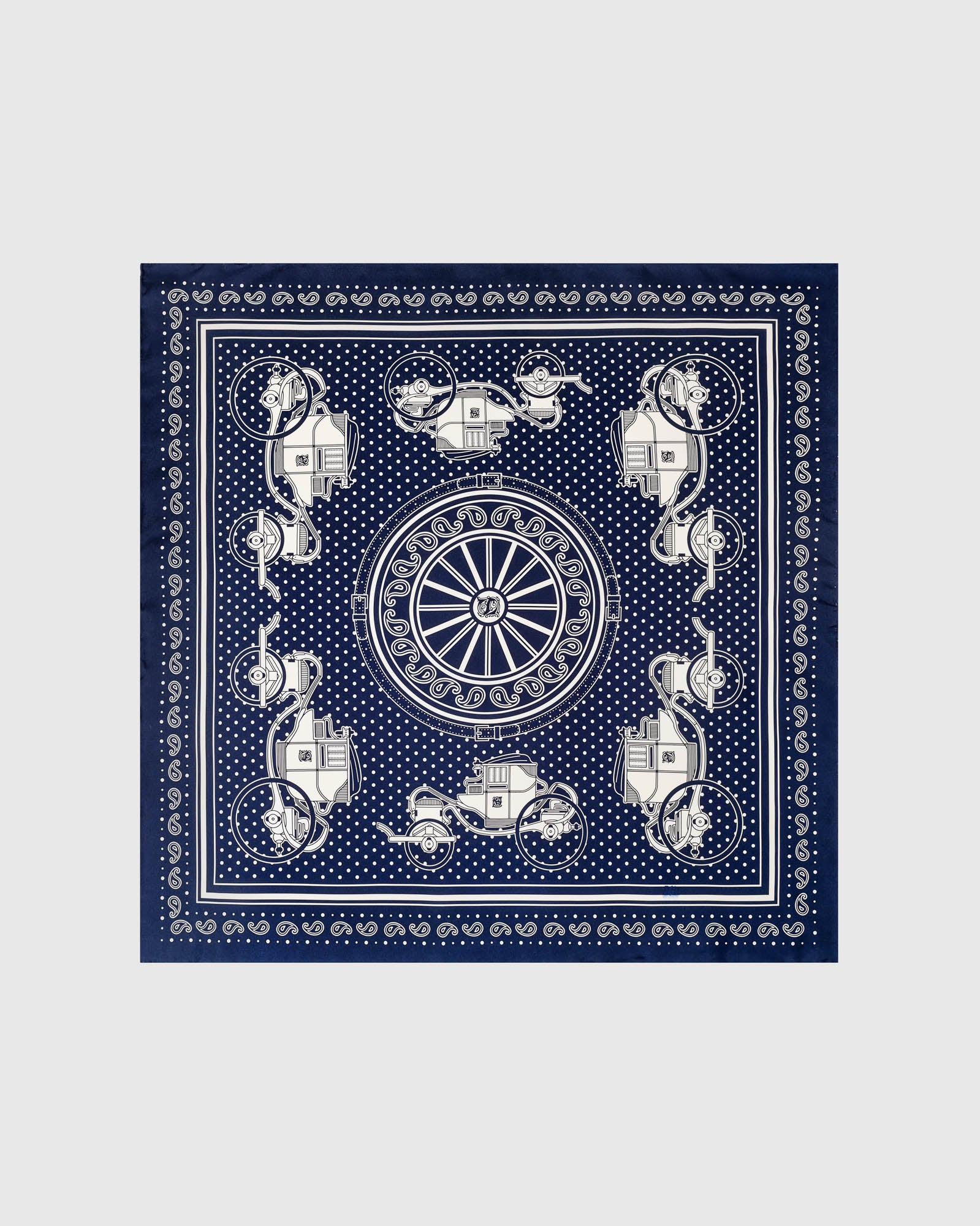 Close-up of the hand-illustrated ivory paisley motif on the navy bandana silk field