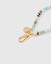 Close-up of gold-plated clasp and engraved STICKYZOO charm disc with aqua stone beads