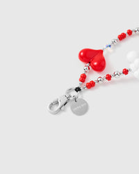 Close-up of silver-tone clasp and engraved STICKYZOO charm disc with red heart detail