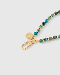 Turquoise stone phone strap worn on wrist showing hands-free carry with phone