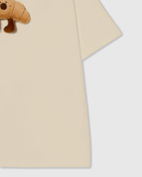 Detail of hem and fabric on STICKYZOO beige Runaway Croissant T-Shirt showing premium cotton weight