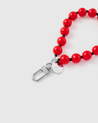 Close-up of silver-tone clasp and engraved STICKYZOO charm disc with red glossy beads