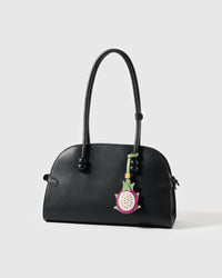 STICKYZOO dragon fruit leather charm on a black top-handle bag showing scale, styling, and bright tropical color contrast