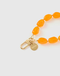 Close-up of gold-plated clasp and engraved STICKYZOO charm disc with amber agate beads