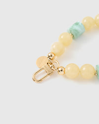 Close-up of engraved STICKYZOO gold clasp with butter round and jade barrel beads