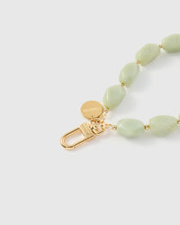Close-up of sage green agate beads showing white marbling and translucent edges