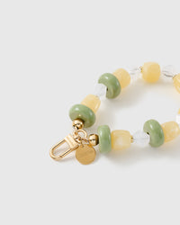 Close-up of the 18K gold-plated hook, engraved STICKYZOO disc and lemon-lime beads — every one different