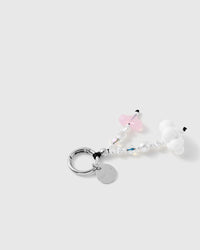 Close-up of the pink jelly heart, white cloud bead, faux-pearl rounds and a faceted iridescent bead beside the silver-tone ring and disc.