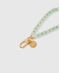 Close-up of gold-plated engraved hook and STICKYZOO charm disc with mint stone beads