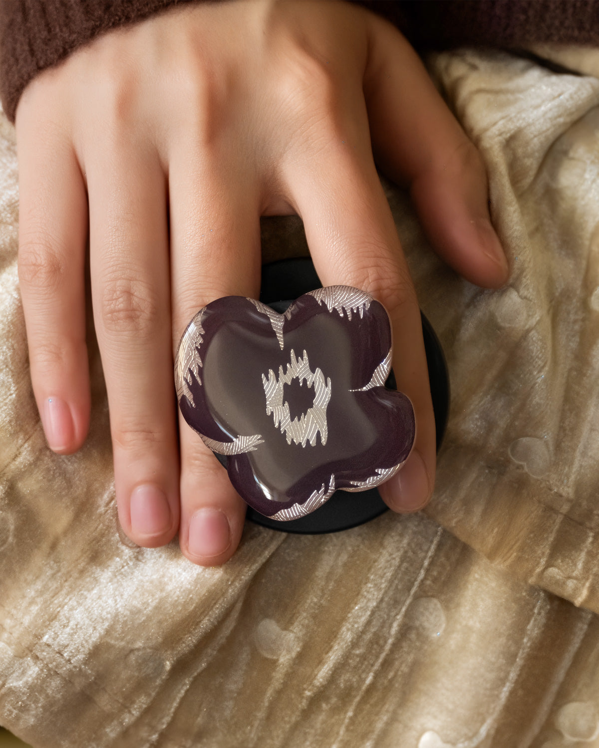 Close-up of the 3D burgundy poppy flower with gold-stitch detail embedded inside the acrylic-resin grip top