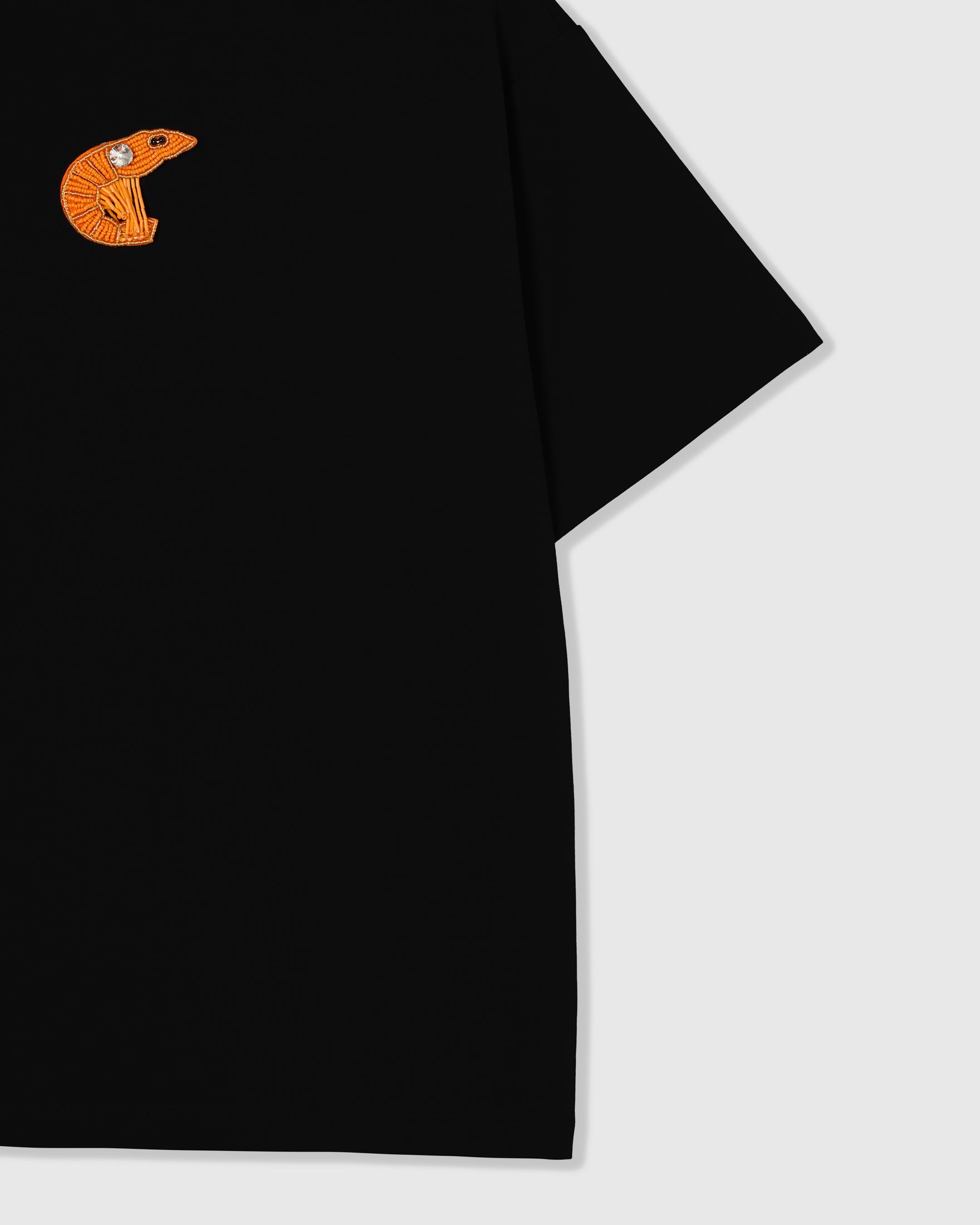 Beaded shrimp appliqué and dropped-shoulder seam on STICKYZOO Shrimp T-Shirt showing the relaxed oversized cut