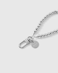 Silver bead phone strap hanging from phone showing sleek wrist carry