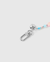 Close-up of silver-tone engraved hardware and heart charm accent on colorful bead strap
