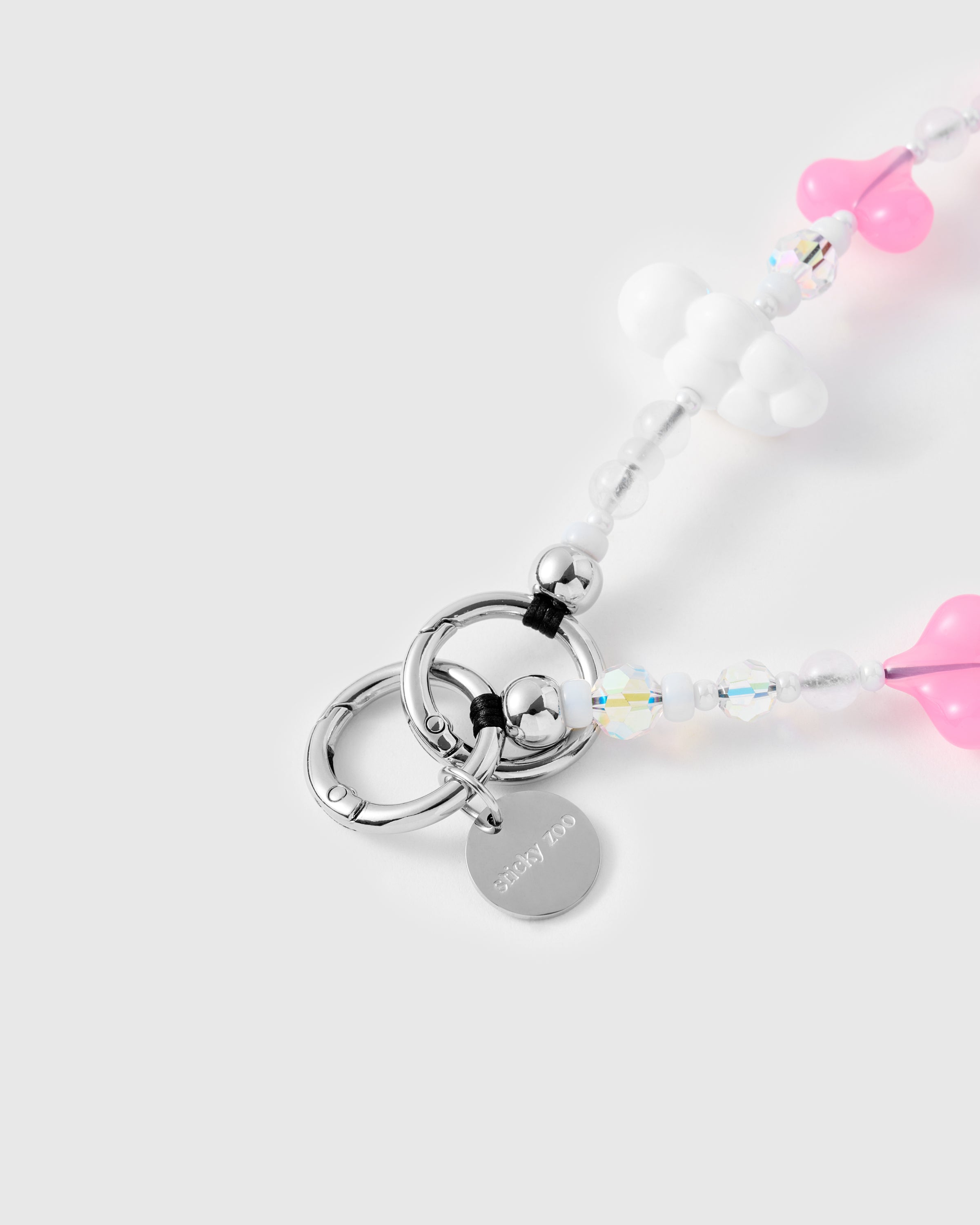 {{Engraved STICKYZOO}} Close-up of silver-tone ring clasp and engraved STICKYZOO charm disc with pink heart beads