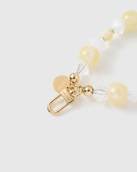 Close-up of gold-plated clasp and engraved STICKYZOO charm disc with butter and crystal beads