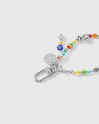 Close-up of silver-tone clasp and engraved charm disc with colorful glass beads