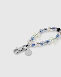 Close-up of the silver-tone lobster clasp, engraved STICKYZOO disc, faceted aurora beads and an iridescent jelly starfish