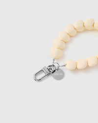 Close-up of silver-tone clasp and engraved STICKYZOO charm disc with ivory heart beads