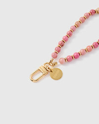 Close-up of 18K gold-plated clasp and engraved STICKYZOO charm disc with pink stone beads