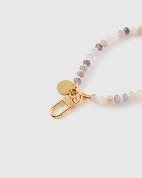 Close-up of gold-plated clasp and engraved STICKYZOO charm disc with blush stone beads