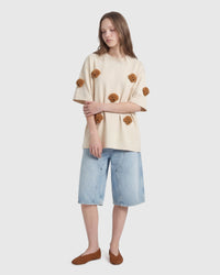 Model in cream Poodle Parade T-Shirt angled pose showing plush poodle appliques
